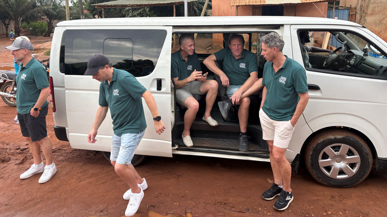 Groep mannen die uit een busje stapt