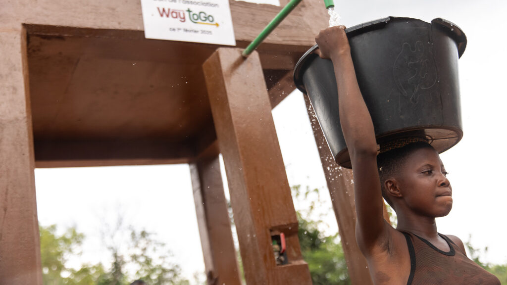 Een vrouw tapt water bij een watertoren
